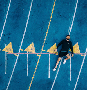 man laying down on running track